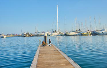Teens taking pictures on the dock of the port of Valencia.
