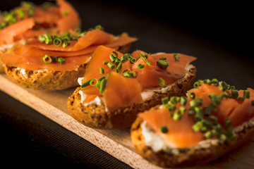 Whole toast with cheese spread and smoked salmon on wooden board