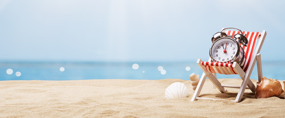 Alarm Clock On Deck Chair On Beach