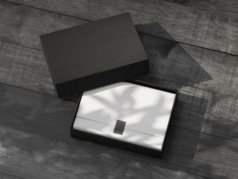 Opened black Gift Box Mockup with white wrapping paper on the wooden table outdoor
