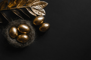  Golden eggs in nest on dark black background.A background for celebrating Easter Top view and copy space  Flatlay. Luxury  background and Minimal black trend 2020.