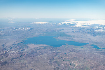 Iceland bird's eye aerial high angle view of Thingvallavatn rift valley lake from airplane window above and snowcapped mountains