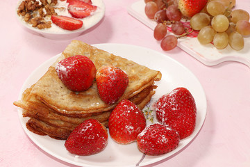 Pancakes with berries, strawberries and grapes, on a sunny sunny background. The concept of healthy and natural food. Healthy breakfast, food for children. selective focus.  Shrovetide