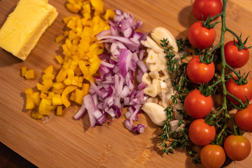 tomates cherry en tabla de madera cuchillo de chef y vegetales ajo cebolla tomillo y pimiento con mantequilla 