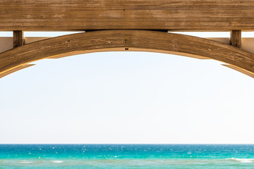 Seaside, Florida abstract closeup of wooden pavilion gazebo architecture by beach ocean background view during sunny day