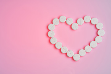 Medicines for the heart lie on a pink background.