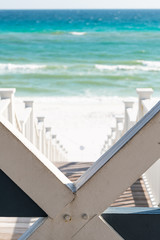 Seaside, Florida railing framing of wooden pavilion gazebo architecture by beach ocean background view down during sunny day