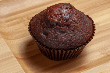 Dark chocolate muffin on wooden dish