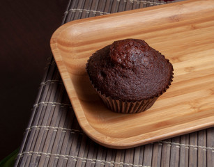 Dark chocolate muffin on wooden dish