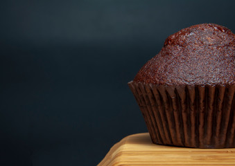 Dark chocolate muffin on wooden dish