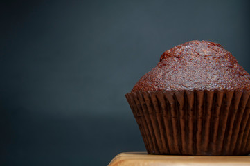 Dark chocolate muffin on wooden dish