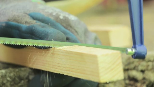 Cutting wood board with a saw. Carpenter working on a hand saw cutting wood