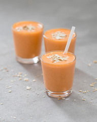 Carrot smoothie drink with oatmeal and banana in a glass