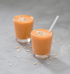Carrot smoothie cocktail with banana and oatmeal in a glass.