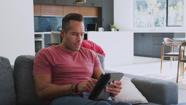 Children Creeping Up And Surprising Father Using Digital Tablet At Home