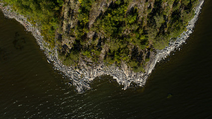 The rocky summer shore of Lake Ladoga.pment in a sunset meadow, with a variety of furrows from work.