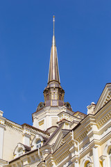 Beautiful building with a spire on a blue sky background. Architectural decorations of buildings in the city of Kiev