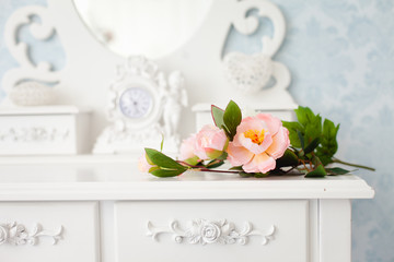 Fototapeta na wymiar Tender tea rose on beautiful white dressing table