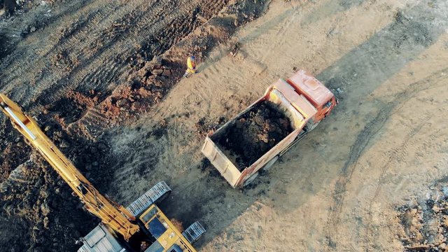 Heavy industrial equipment working. Top view of industrial machines relocating excavated soil