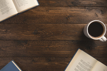 Open books, cup of coffee, on wooden background. Flat lay, top view, copy space.