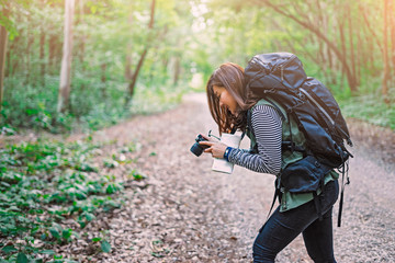 Traveling Asian woman Photographer backpack on a path the tropical forest looking camera to create photo contents in green rainforests. Summer holiday vacation trip Survival travel, lifestyle concept