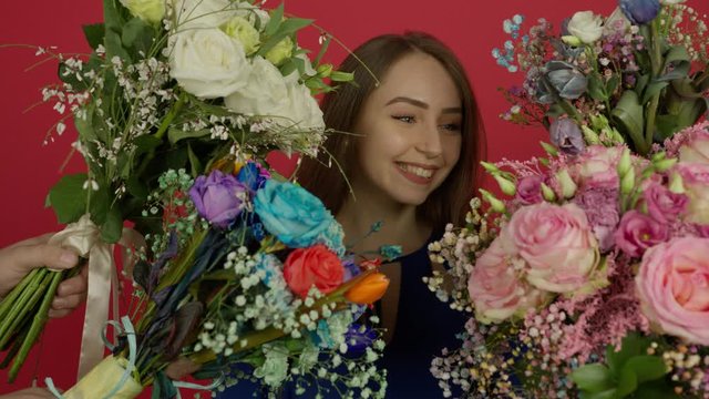 Excited beautiful girl looking at bouquets with smile and taking eustoma flowers