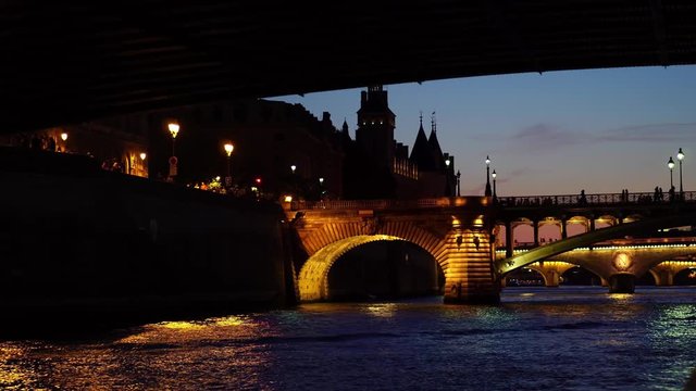 Paris at night, Seine river bridge. Seen from tour sightseeing boat ship. Paris at night. Romantic honeymoon travel destination. Historic landmark.