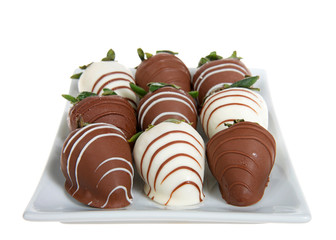 Rectangular porcelain plate of giant strawberries dipped in white and milk chocolate, drizzled with contrasting white and milk chocolate. Isolated on white