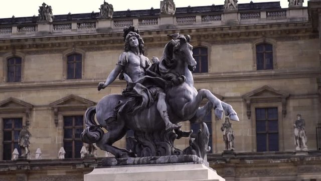 Statue in front of Louvre Museum building. Famous tourism  landmark in Paris. Slow motion glide. 