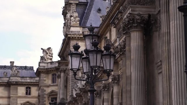 Glide shot slow motion. Lamps in front of Louvre Museum building. Famous tourism landmark in Paris.  