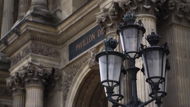 Glide shot slow motion. Lamps in front of main entrance to Louvre Museum building. Famous tourism landmark in Paris.  