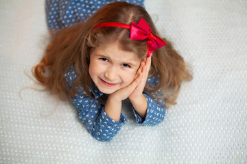 Young girl sitting on bed in the bedroom