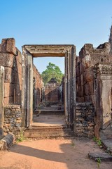 door leading to entrance of angkor wat temple ruins tower with blue sky, cambodia