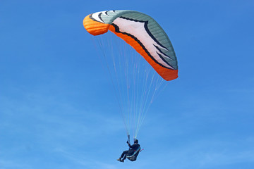 Paraglider flying wing in a blue sky	