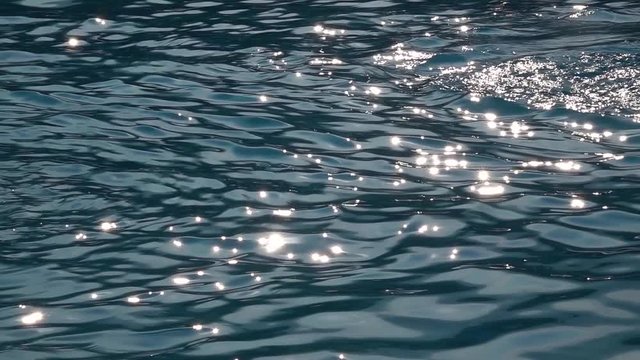 Sunny rays playing in the sea waves. Slow motion. Close up