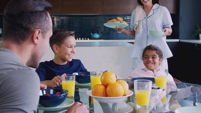 Hispanic Family Sitting Around Table Eating Breakfast Together
