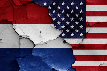 flags of Netherlands and USA painted on cracked wall