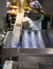 Production line collecting empty plastic bottle from blowing machine before packing in plastic bag