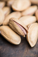 Pistachios in shell on the black rustic background. Selective focus. Shallow depth of field.