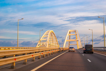 Obraz premium Crimean bridge with walking transport at dawn