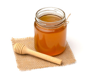 Honey dipper and honey in jar on white background,copy space.