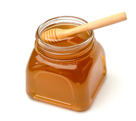 Honey pot and dipper isolated on white background .
