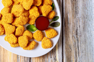 Chicken nuggets with sauces on wooden background.