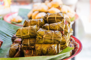 Thai dessert made from banana and glutinous rice, wrap with banana leaf (Khao Tom Mat or Khao Tom Pad) on pan zinc coating vintage, kitchen utensil in Thailand.