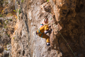 A girl climbs a rock.