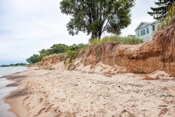 Beach houses on Lake Michigan, lake erosion dangerously close to houses, half the beach is gone due...