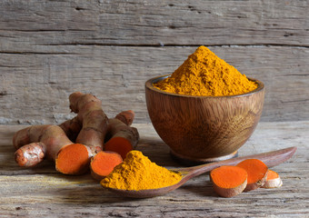 Turmeric powder and fresh turmeric (curcumin) on wooden background,Used for cooking and as herbal medicine,copy space.