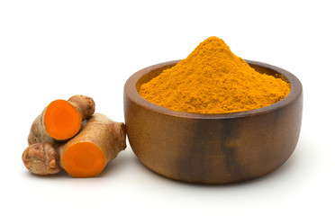 Turmeric powder in a wooden bowl and turmeric (curcumin) rhizomes isolate on a white...