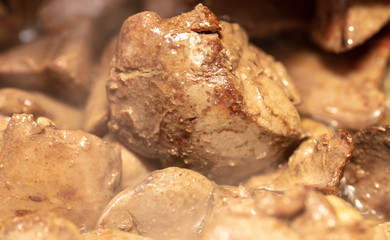 Chicken liver is fried in a pan.