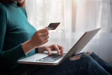 Woman using a credit card and digital laptop.